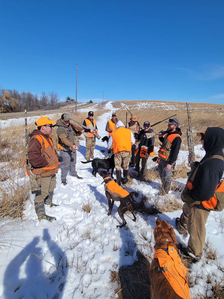 Group of hunters and dogs on a corporate pheasant hunt in the snow