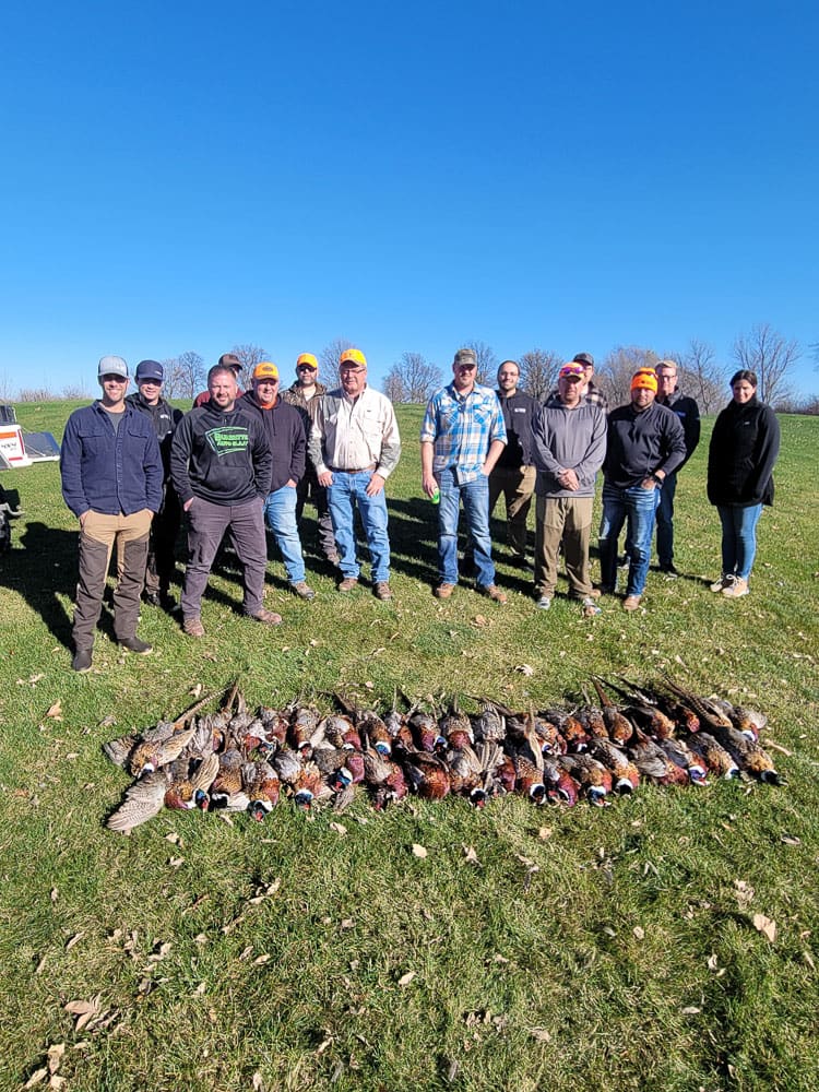 Group of hunters with dogs and harvested birds