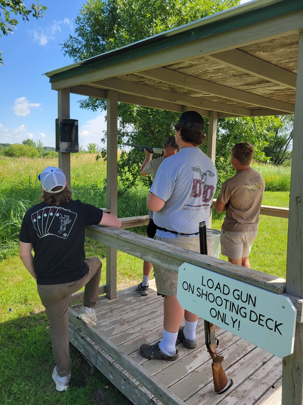 Sporting clays shooting deck with load-gun-on-deck safety sign
