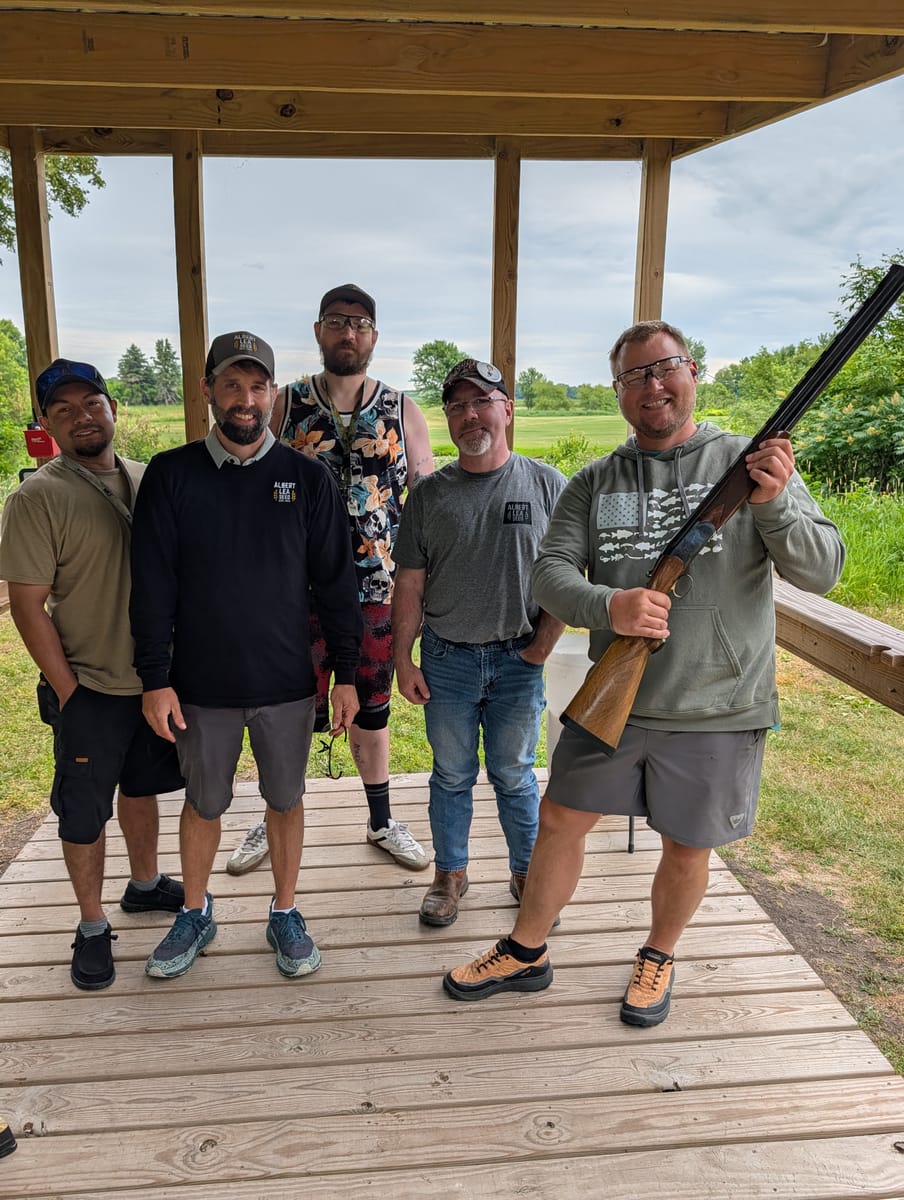Group of shooters smiling together after a round of sporting clays